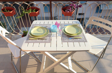 Served table on balcony. Food and lifestyle. Traditional buildings in Italy.
