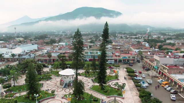 Aerial: cityscape and central square during the day in Tuxpan, Jalisco, Mexico, establishing drone shot
