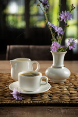 Coffee and flowers on a rustic table in a cozy, serene environment during the afternoon light