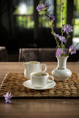 Freshly brewed coffee with delicate flowers on a rustic wooden table in a cozy setting