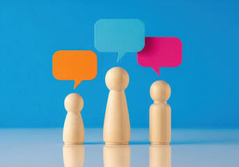 Three wooden figures with colorful speech bubbles representing communication and ideas