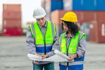 Industrial container workers discuss sustainable logistics operations. Analyzing blueprint, including zero emissions, reducing fuel consumption and carbon footprint in supply chain management