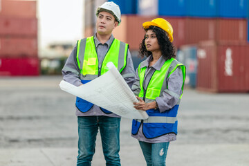 Industrial container workers discuss sustainable logistics operations. Analyzing blueprint,...