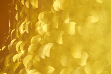 Abstract yellow bokeh effect with soft circular light patterns and warm golden glow.