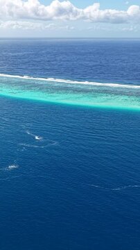 French Polynesia, Vertical Drone Shot of Coral Reef Barrier, Lagoon and South Pacific Ocean Horizon