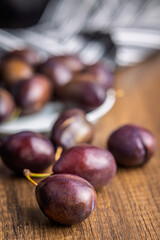 Ripe plums on wooden table.
