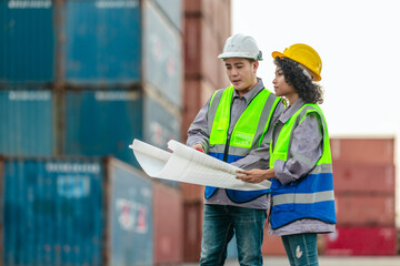 Industrial container workers discuss sustainable logistics operations. Analyzing blueprint, including zero emissions, reducing fuel consumption and carbon footprint in supply chain management