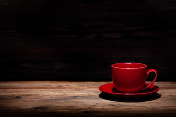Coffee cup on a table in front of a dark black background