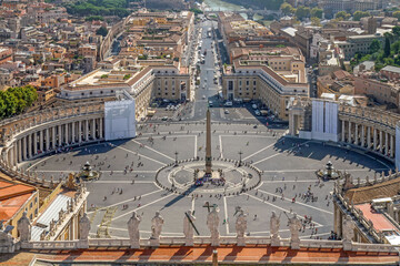 Panoramic aerial view of St. Peter's Square in Vatican City with central obelisk, surrounding colonnade and historic architecture. Famous religious and cultural landmark in Rome, Italy.