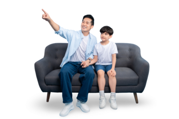 A father and son sitting on a couch, pointing. The father wears a light blue shirt, and the son is in a white shirt on PNG background.