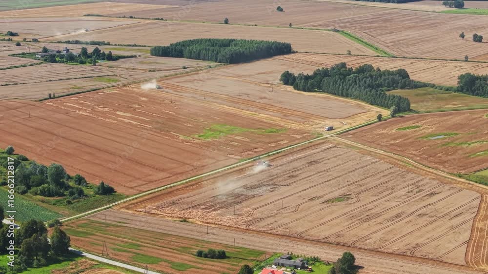 Poster drone overview of large combine harvesting grain fields with dry landscape around