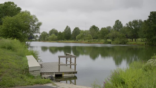 A fishing pier on a small lake on a dreary overcast day. Cloudy.