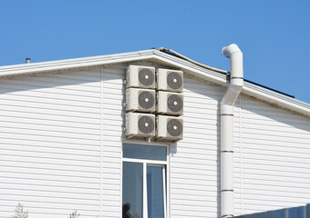Ventilation and air cooling system in the house. Six air conditioners on the facade of the house.White color on house siding walls for energy saving.