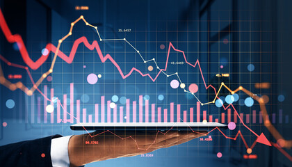 Businessman holding tablet with falling stock market graph and red arrows representing financial crisis and global economic downturn concept.