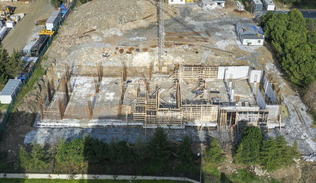 Aerial view of the intricate skeleton of a building under construction, juxtaposing raw concrete with the warm tones of wooden framework, Avc&Auml;&plusmn;lar, &Auml;&deg;stanbul, T&Atilde;&frac14;rkiye.