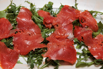 piatto con fette di salmone affumica e rucola