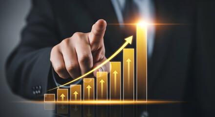 Businessman pointing at a holographic projection of a rapidly increasing gold bar graph symbolizing significant growth and financial success.