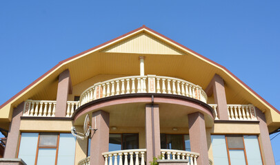 The facade of a beautiful house with semicircular balconies and columns.