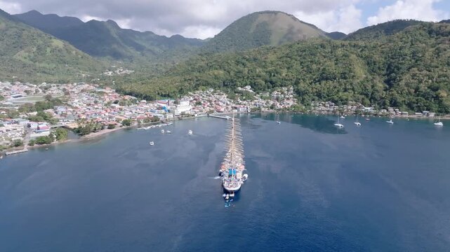 Aerial view of the tall ship in the harbor near Le Pitons, contrasted against the lush green mountains and the deep blue sea, Le Pitons, Soufri&egrave;re, Saint Lucia.