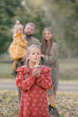 Portrait of a beautiful little girl blowing out a number nine candle on her birthday, with her...
