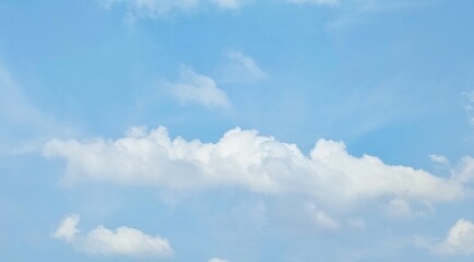 Blue sky with fluffy white clouds, peaceful and calm view. Nature background. Blue sky landscape.