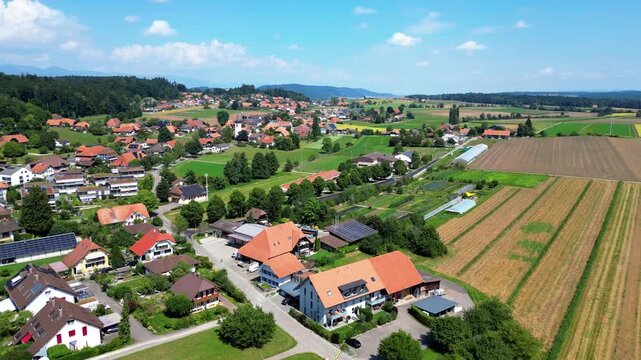 Aerial view of Grossaffoltern village showing the church surrounded by lush green fields and traditional houses, creating a picturesque scene, Grossaffoltern, Berne, Switzerland.