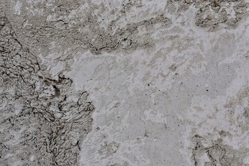 Concrete cement wall with gravel filled hole in the surface for abstract concept graphic design.