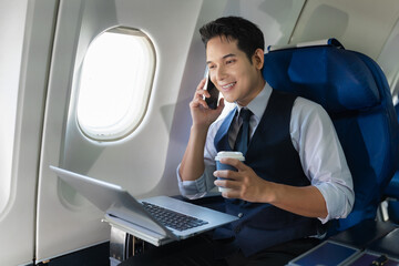 Traveling and technology. young business man working on Laptop and smartphone while sitting in...