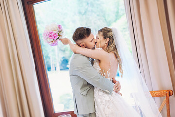  happy, laughing bride and groom kissing at the wedding. Celebrate an emotional wedding.