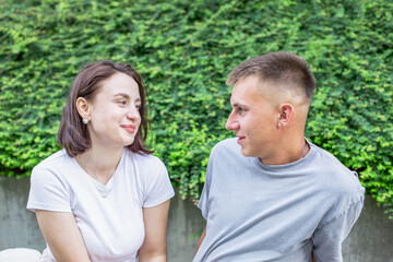 Obraz premium Happy young couple on a date in the park, joyfully talking and admiring each other while enjoying their time together outdoors.