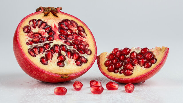 Juicy Pomegranate Halves with Seeds, Vibrant Red, Fresh and Clean Studio Shot.