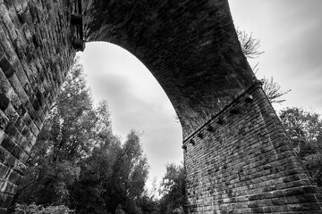 Stone arch of Saddleworth Viaduct in monochrome