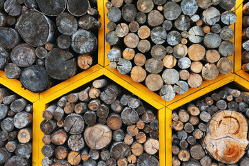 Close-up background and texture of firewood stacked in yellow honeycombs.