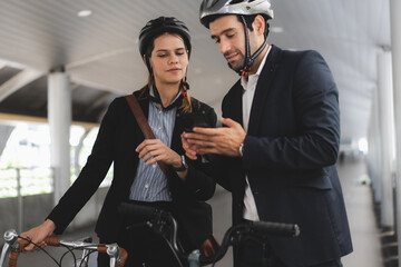 Obraz premium Commuting to work with bicycle. Businessman businesswoman cycling to office in downtown district. Modern diverse people use eco transportation on city street. Environmental pollution, climate change.