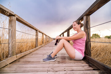 Tourist relaxing on wooden footbridge in nature reserve