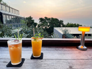 Sunset silhouettes with zestful cocktails, echoing World Cocktail Day vibes, rooftop romance, urban escapade, summer twilight epiphany