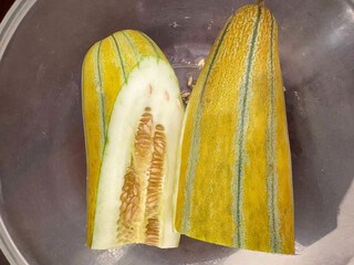 Golden-striped melon halves, reminiscent of ancient solstice feasts, evoke rare heirloom harvest,...