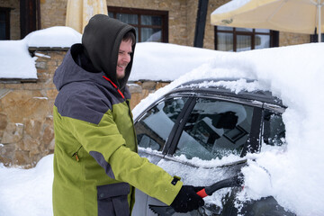 Person Clearing Snow from Car in Winter Landscape