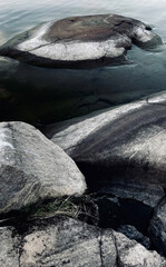 Silent granite sentinels cradle icy Nordic waters, whispering tales of Midsummer mysteries and ancient Runic rituals