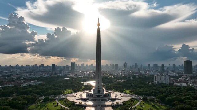Wide Cinematic Aerial Shot of Monas National Monument with Sunlight Rays and Dramatic Clouds