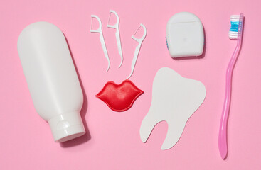 Two white tubes of toothpaste, dental floss in a case, plastic holders for dental floss, red...