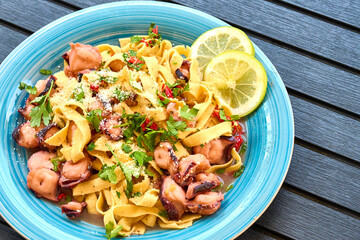 Octopus Pasta Dish with Lemon and Parsley Garnish