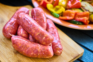 Fresh Sausages with Colorful Bell Peppers, Wood Background