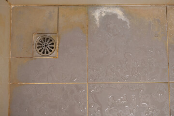 bathroom with a toilet. dirty joints between the tiles, toxic black mold in the corner. Clogged and...