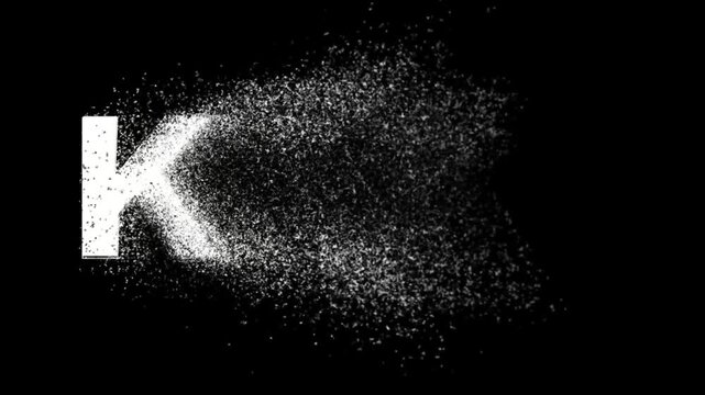 Disappearing English alphabet K into small particles on plain black background