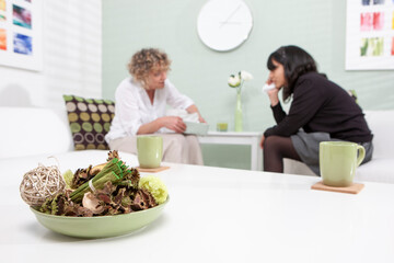Student Counsellor. A candid view of a counselling session between an emotional young teenage girl and her therapist offering support. Anonymous portrait with focus on the foreground content.