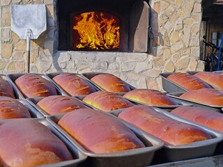 In the background, the fire is blazing in the oven, while in the foreground, there are many freshly...