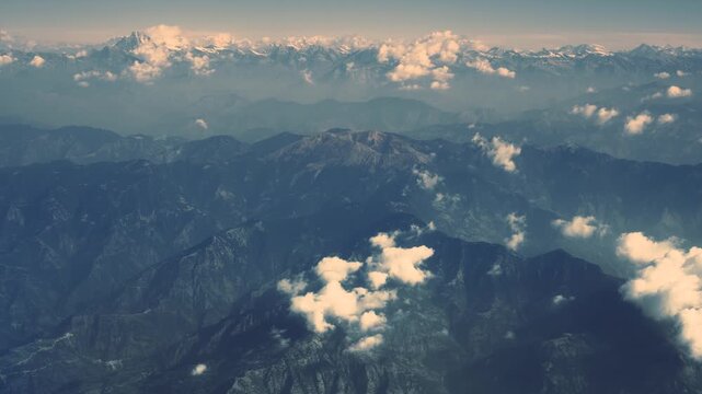Aerial view of the majestic mountains, where white clouds dance among the peaks, creating a stunning contrast against the deep blue valleys, Musikot, Lumbini Province, Nepal.