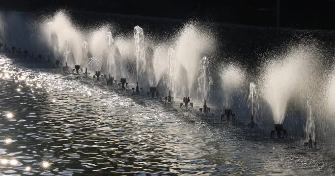 Row of fountains creating a stunning water display with sunlight glistening on the surface, producing a visually appealing spectacle. Bardejov town in North-Eastern Slovakia, Europe.