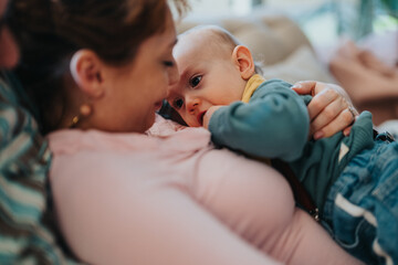 A mother tenderly cradles her infant, creating a heartfelt and affectionate scene that emphasizes...